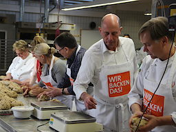 Präsident Lobenstein (r.) und Wirtschaftsminister Tiefensee (2.v.r.) bestimmen das Gewicht der Stollen-Teigmasse. 