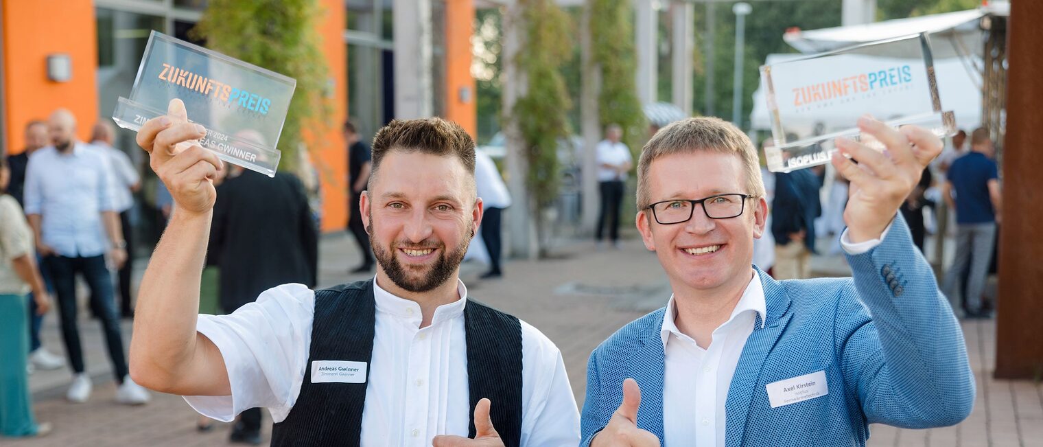 Sie sind die strahlenden Gewinner des Zukunftspreises 2024: Andreas Gwinner von der Zimmerei Gwinner (links) und Axel Kirstein von der isoplus Fernwärmetechnik GmbH.